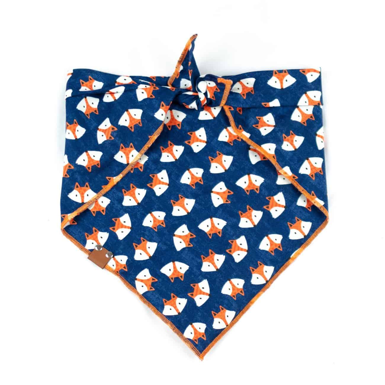 Navy blue dog bandana with orange and white fox print and orange hem